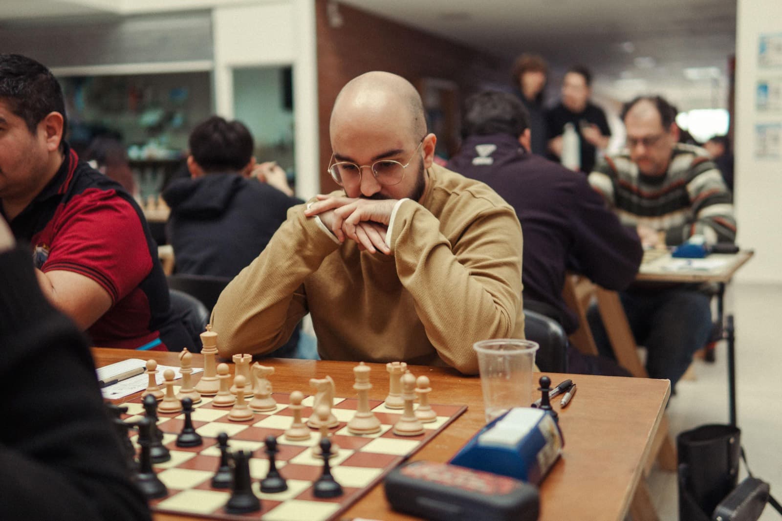 Lucas studying the board at a chess tournament