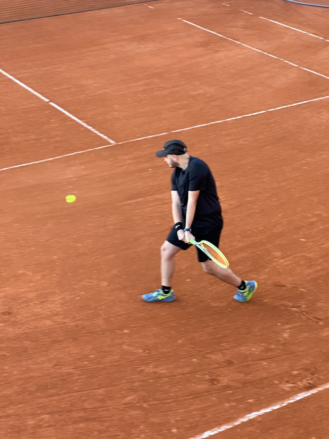 Lucas playing tennis on a clay court